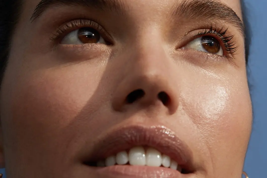 A before image of a young woman's face demonstrating the morning micellar water routine.
