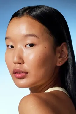 a young girl looking into the camera with shiny skin