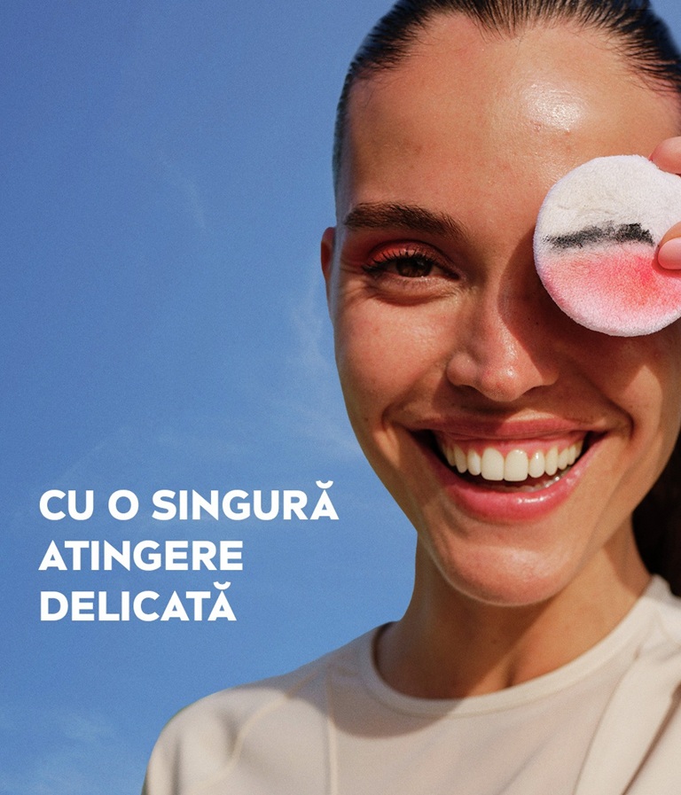 A woman leans back and gazes, holding the Derma Skin Clear Serum-infused Micellar Water under her chin.