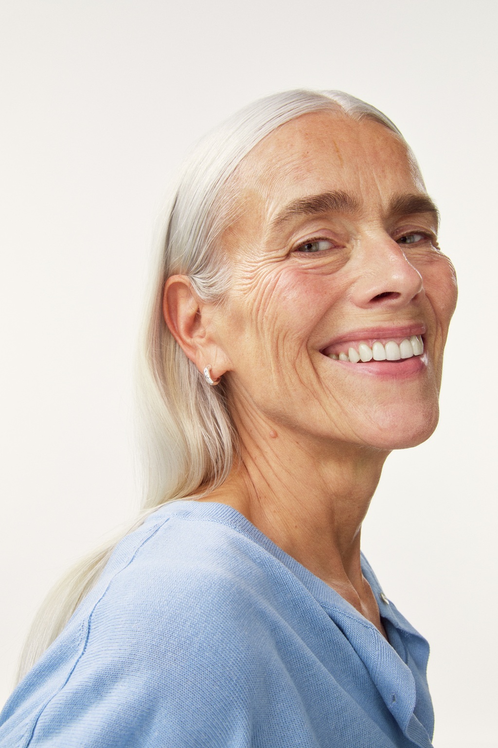 close up of a smiling old lady in a blue shirt