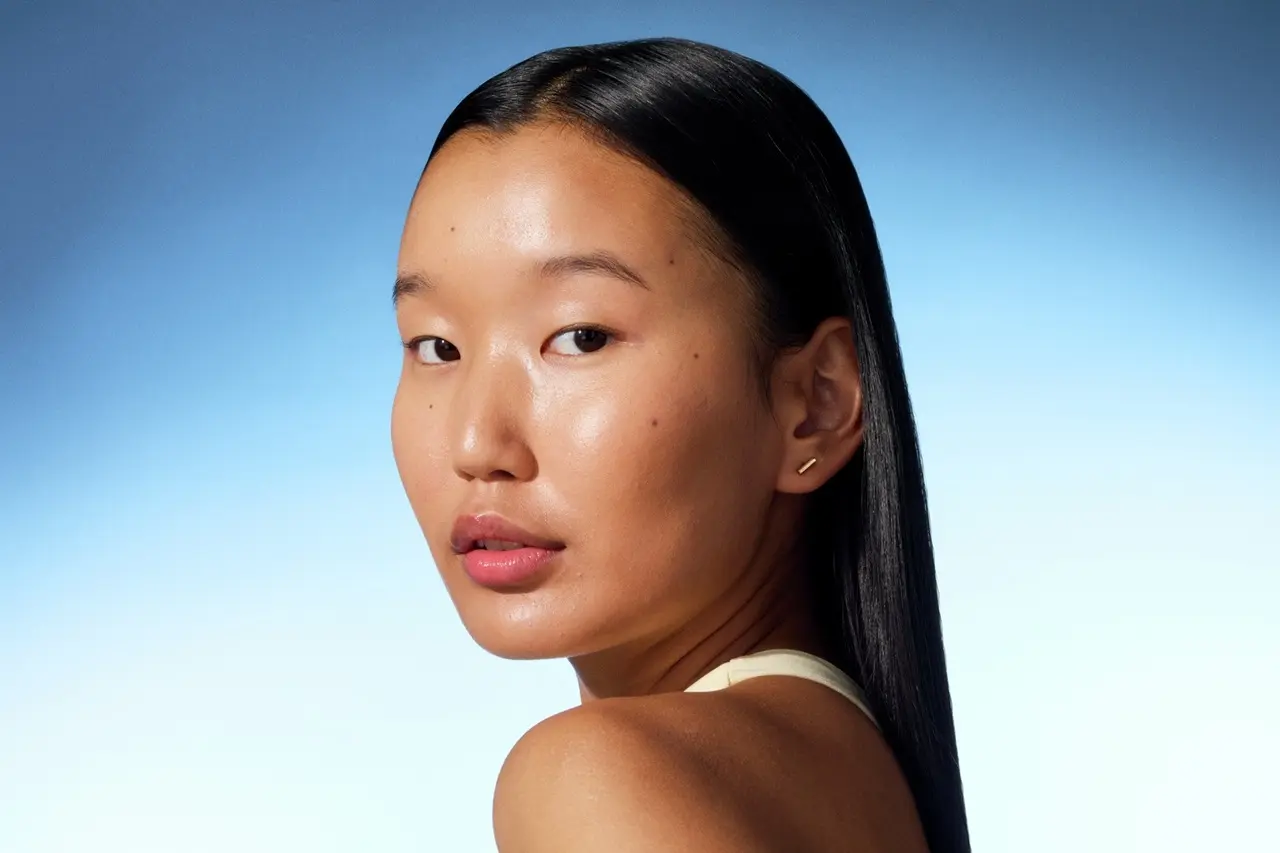 a young girl looking into the camera with shiny skin