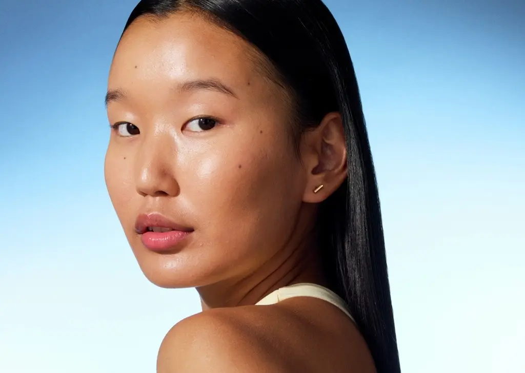 a young girl looking into the camera with shiny skin