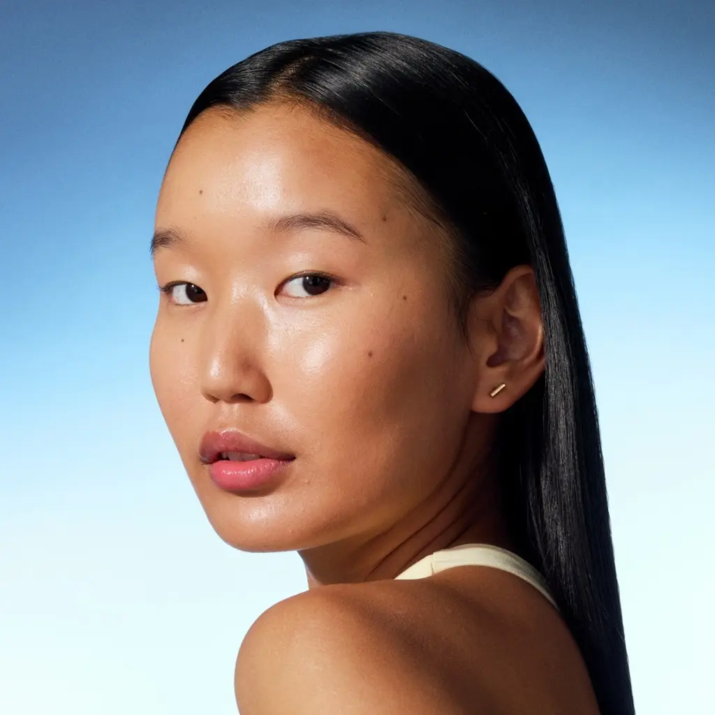 a young girl looking into the camera with shiny skin