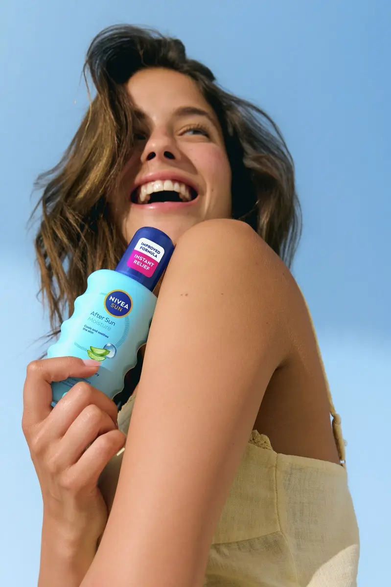 Young woman using Nivea After Sun Moisture Spray