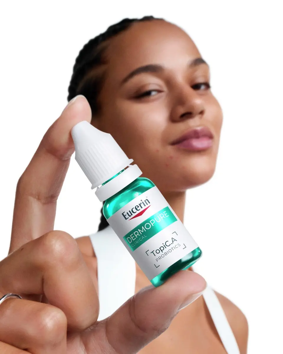 Woman holding a bottle of Eucerin TopiC.A skin-native probiotics from the Probiom8 kit