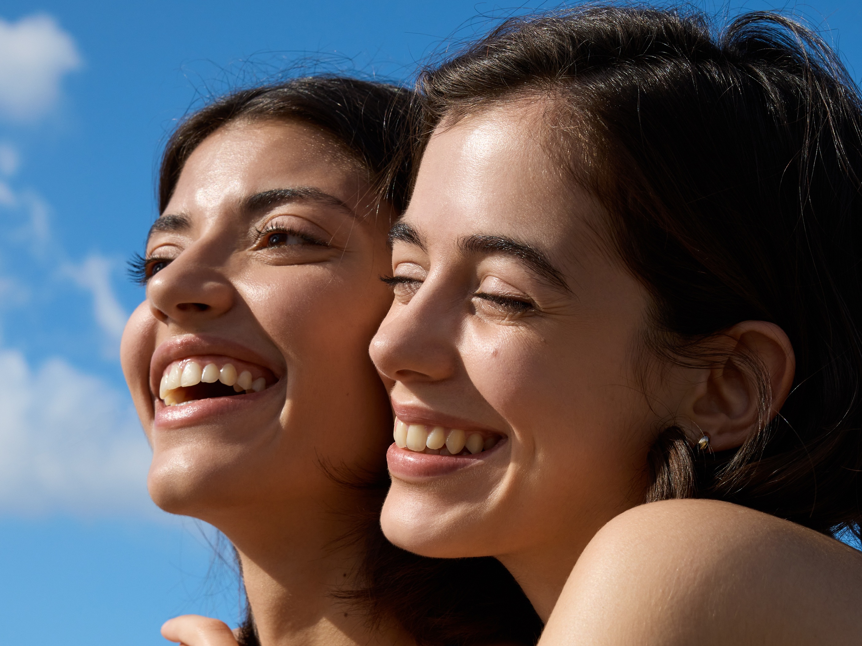 two young girls standing in the sun