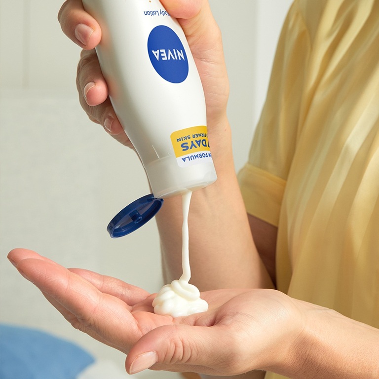 Woman pouring Q10 Body lotion on her hand to deal with loose skin