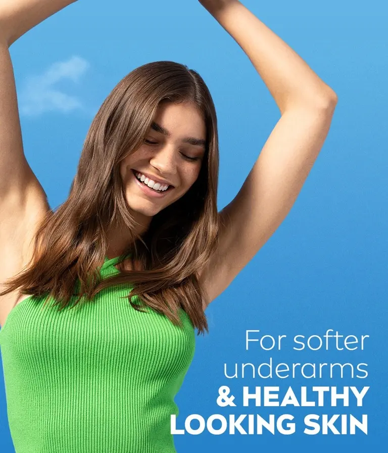 A woman looking downwards, with both arms raised over her head showing her smooth, even underarms.