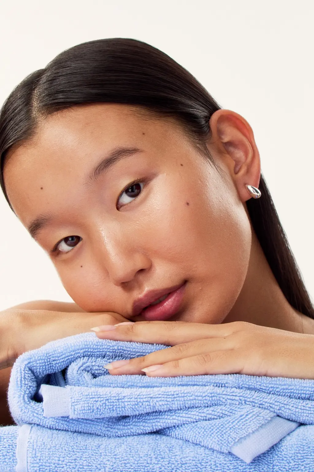 a young girl laying her head on a pile of towels