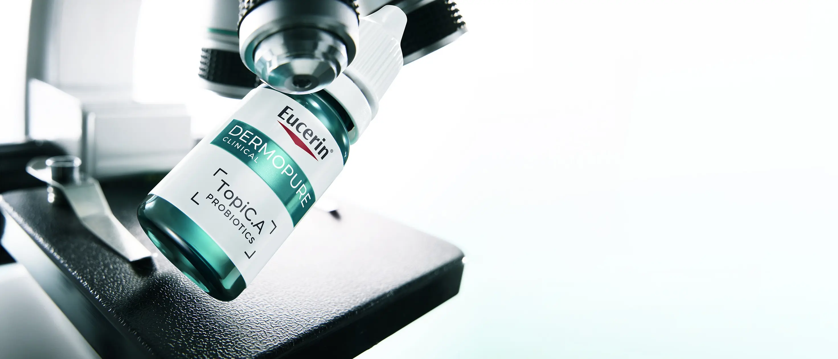 Bottle of Eucerin Probiom8 TopiC.A beside a microscope