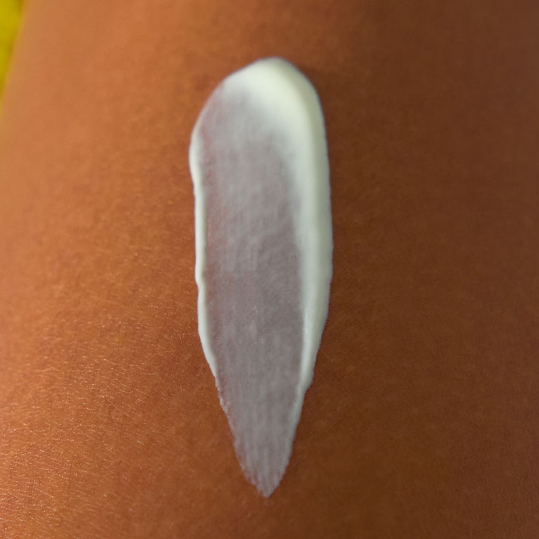 Close-up of a smooth swipe of sunscreen lotion on bare skin.