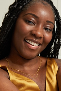 Young black woman using Q10 Firming+ Energising Body Serum-Lotion