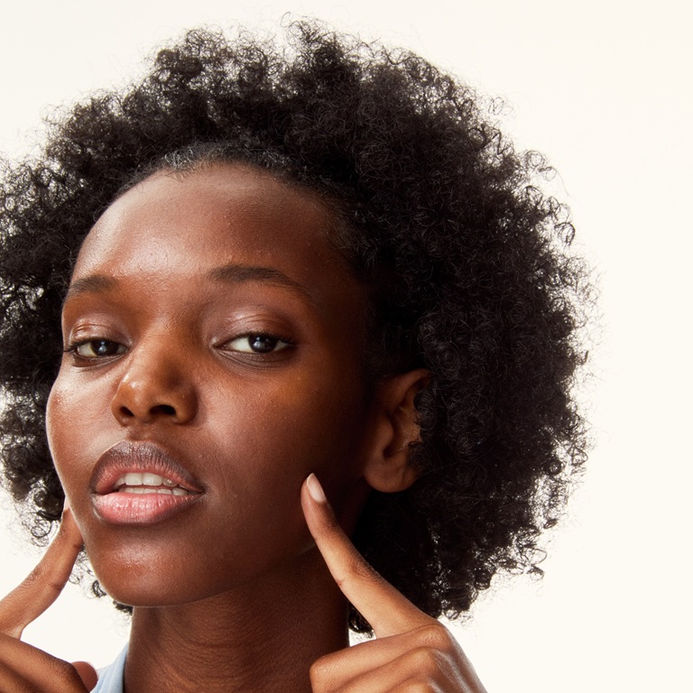 young woman pointing her fingers to her own face