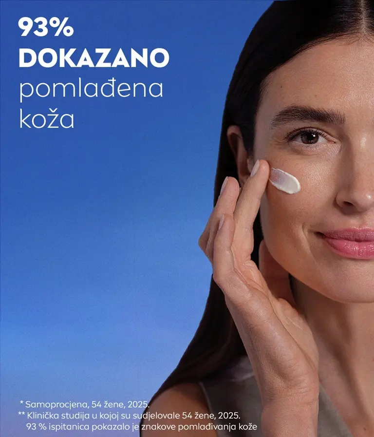 Žena gleda i blago se smiješi te pritom nanosi NIVEA CELLULAR Epigenetics dnevnu kremu za pomlađivanje sa SPF 30 na obraz.