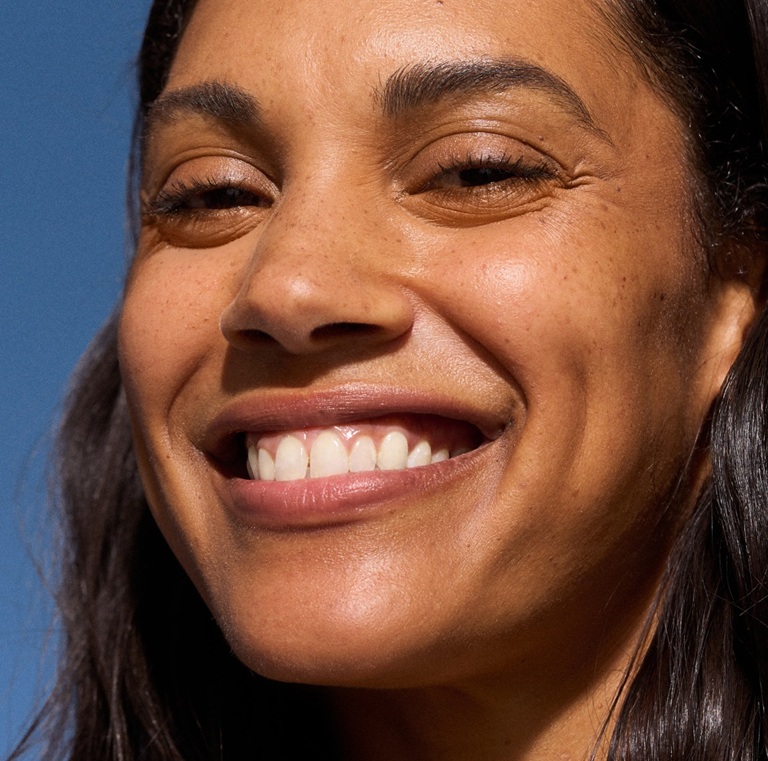 femme brune souriante avec des taches de rousseur