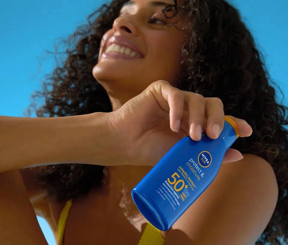 Young woman using NIVEA Protect & Moisture SPF 50+