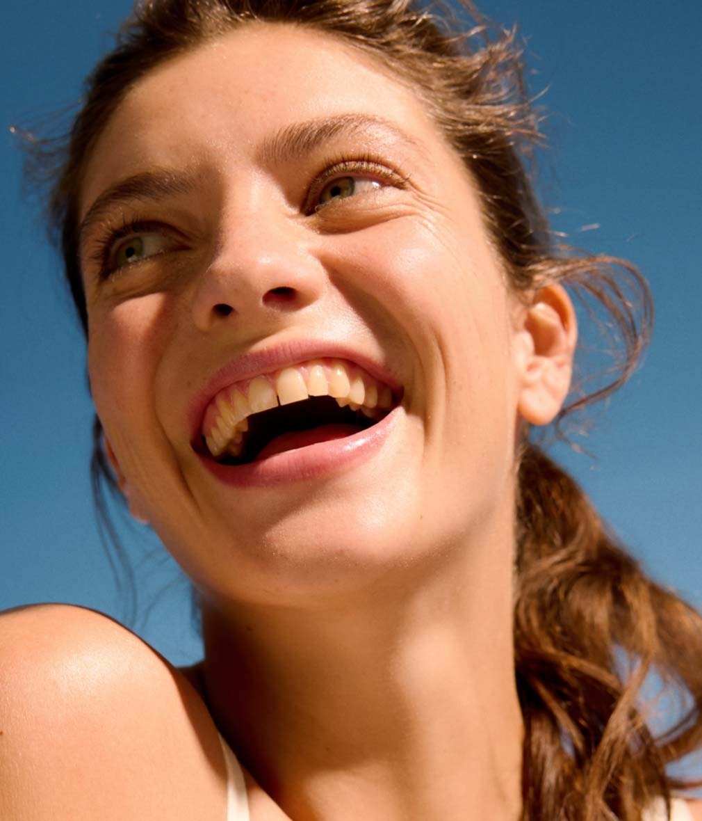 Woman smiling with clear skin after using facial scrub